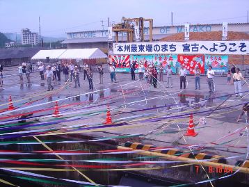 Group on land bidding farewell to ship and holding streamers